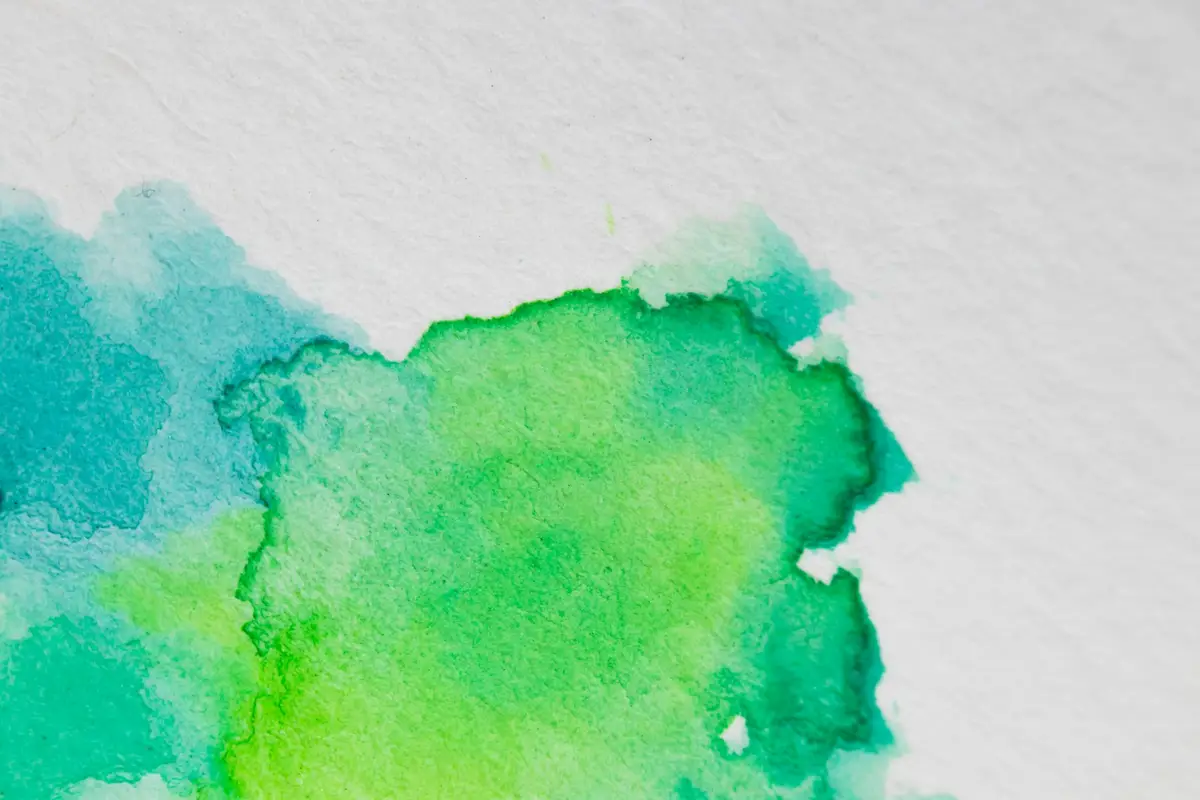 Mancha de aguarela em verdes e turquesas fundidos sobre papel branco – Totenart