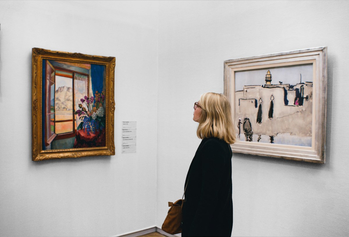 Visitante a olhar para um quadro abstrato numa sala de museu, totenart